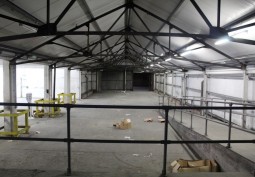Dark warehouse with ramp and concrete pillars for filming