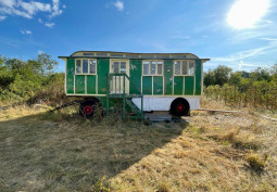 Green mobile home in a field. Available for filming