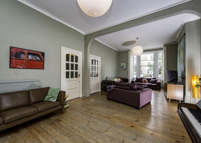 7. Large open plan dual-lounge with pale sage green walls.
