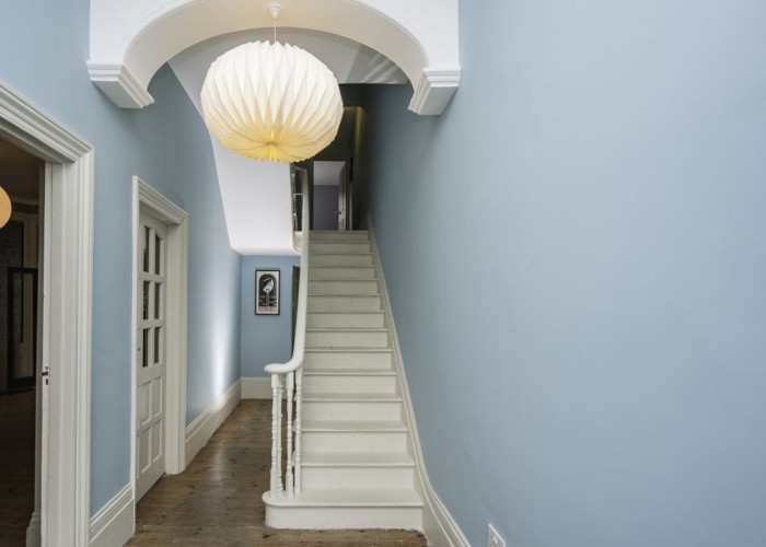 17. spacious hallway with pastel blue walls and many original features