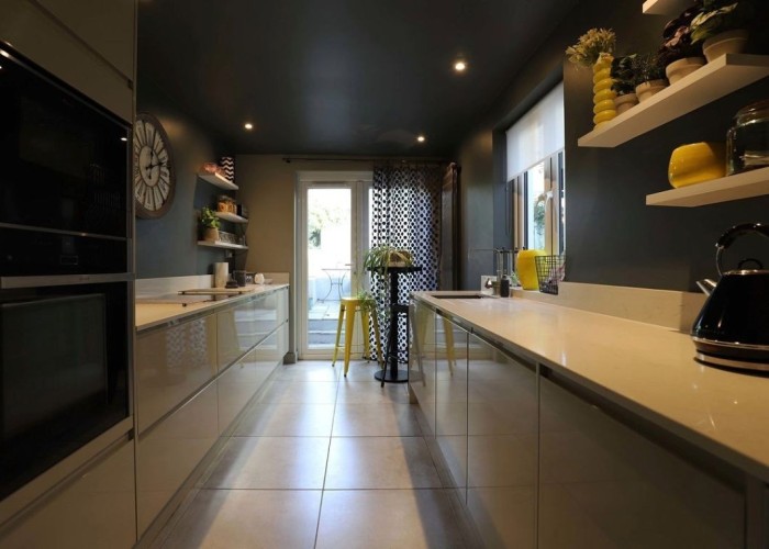 3. Film Location: Galley kitchen with modern cream units and dark wallcolour