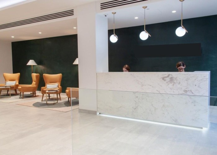 2. Contemporary office reception with smart dark back wall. This reception can be hired as a film location in Central London.